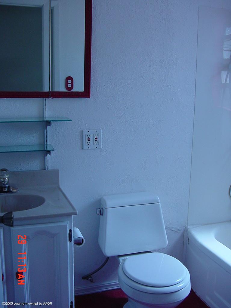 4007 Cline Road Amarillo, TX 79110 - Photo 8 of 11 a bathroom with a toilet and a sink