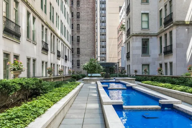 a swimming pool with outdoor seating water view and buildings