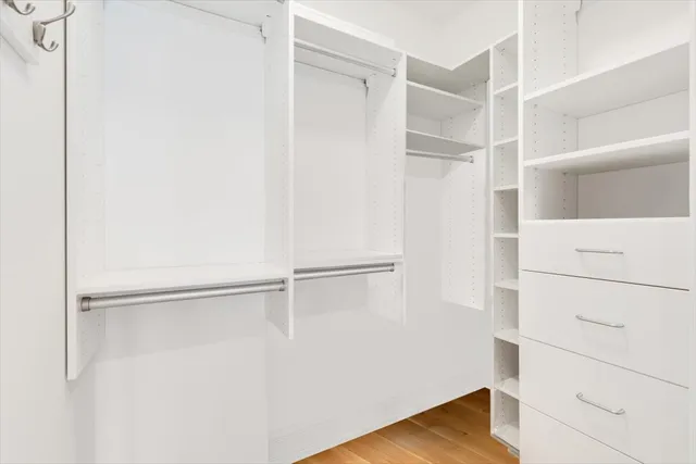 a view of a hallway with white walls and cabinet