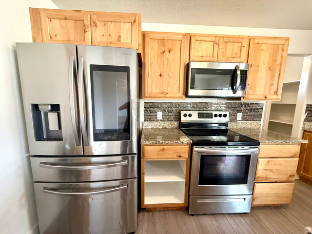 1823 South Longview Road Santaquin, UT 84655 - Photo 21 of 69 Stainless steel appliance suite featuring a French door refrigerator with an external dispenser, a freestanding electric range, and an over-the-range microwave