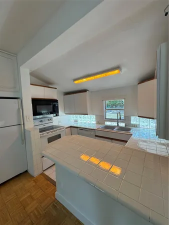 a kitchen with stainless steel appliances kitchen island granite countertop a sink and a stove