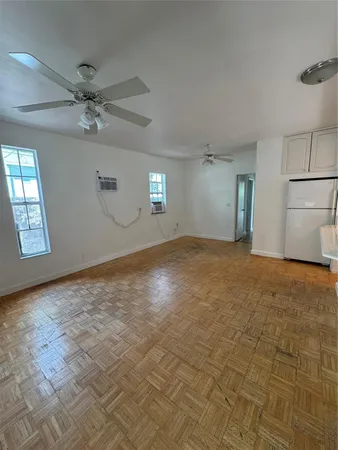 an empty room with fan and windows