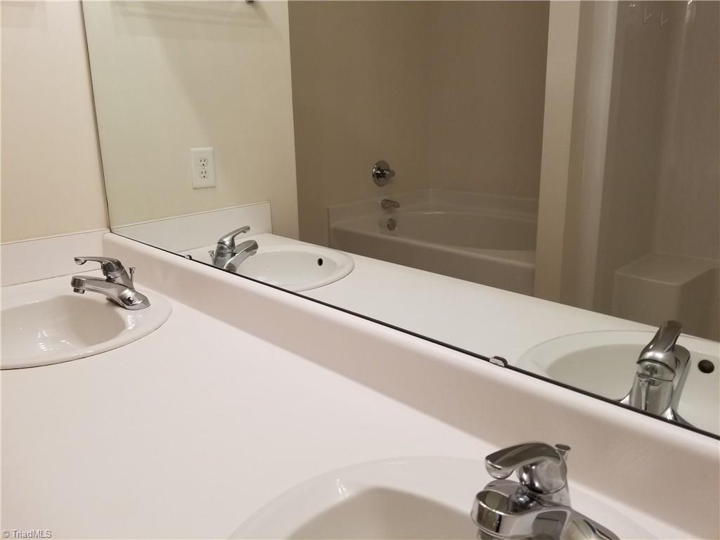 2940 WaterStone Loop High Point, NC 27265 - Photo 6 of 16 Double sinks and a reflection in the mirror of the garden tub and shower