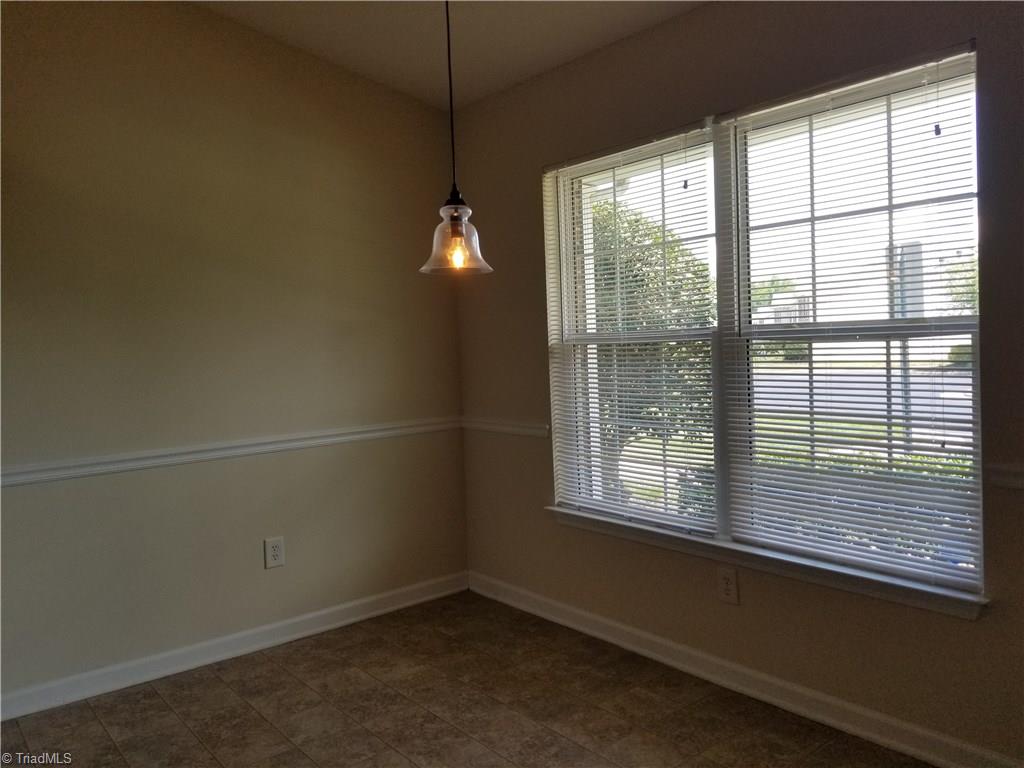 2940 WaterStone Loop High Point, NC 27265 - Photo 10 of 16 The eating area shows the updated light fixture, chair rail molding, and the double windows overlooking the front of the home.