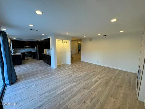 an empty room with wooden floor and entrance