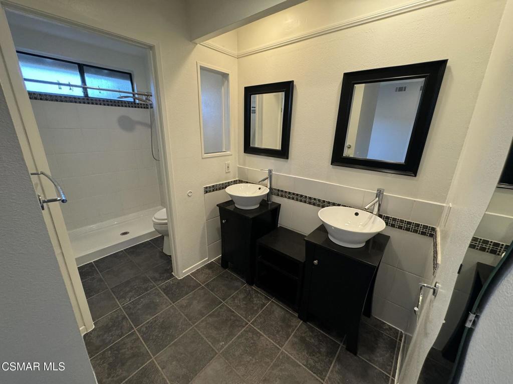 13654 Blacksmith Court Moorpark, CA 93021 - Photo 20 of 34 a bathroom with a double vanity sink toilet and mirror