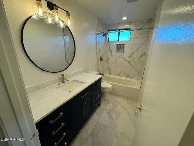 a bathroom with a double vanity sink mirror and toilet
