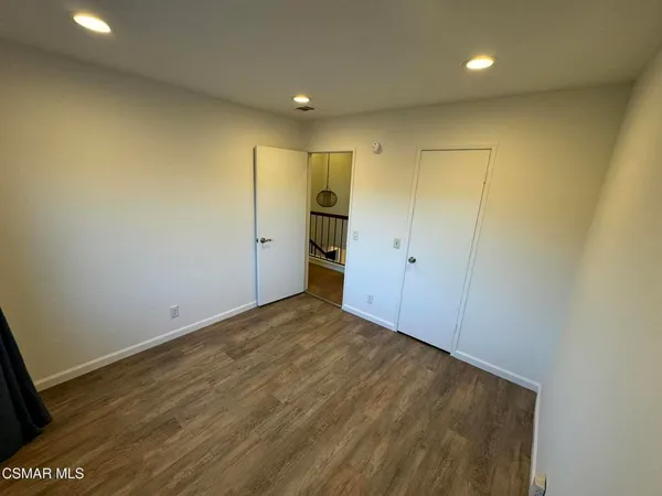 a view of hallway with wooden floor and fence
