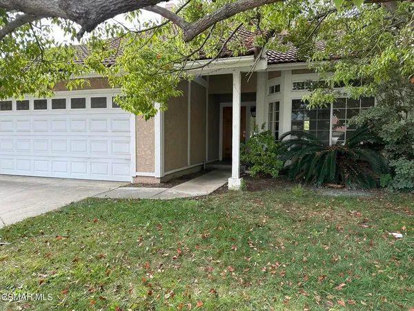 a view of house with backyard and glass windows