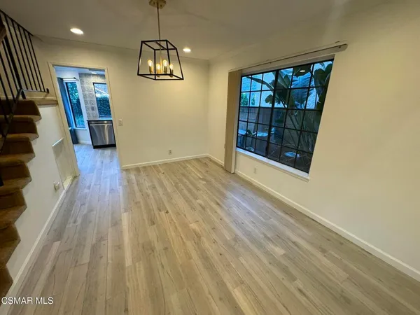 a view of a livingroom with wooden floor and stairs