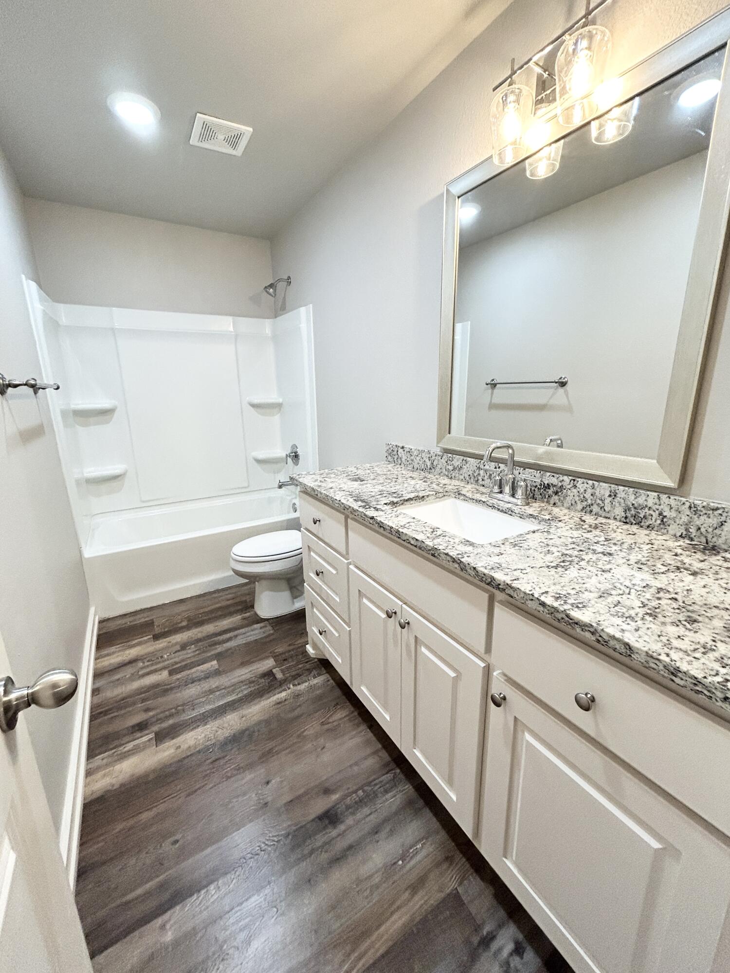 5512 122nd Street, Unit B Lubbock, TX 79424 - Photo 5 of 9 a bathroom with a granite countertop sink and a mirror