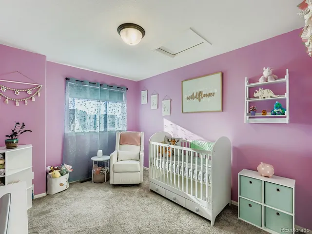 a bedroom with pink baby crib and a window