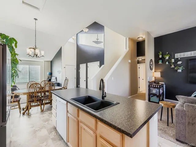 a kitchen with stainless steel appliances kitchen island a table and chairs in it