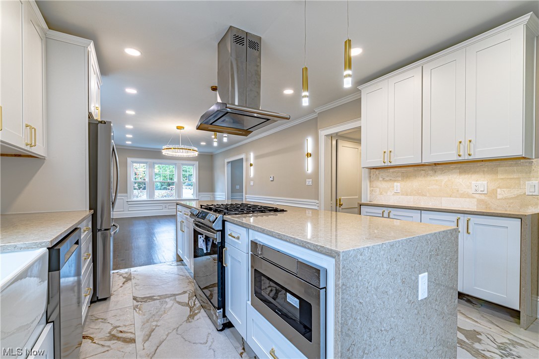 2923 Huntington Road Cleveland, OH 44120 - Photo 13 of 35 Kitchen with light wood-type flooring, decorative light fixtures, island exhaust hood, and a kitchen island