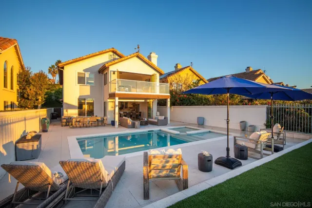 a view of a house with pool and chairs
