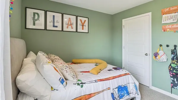 a bedroom with a bed and painting on the wall