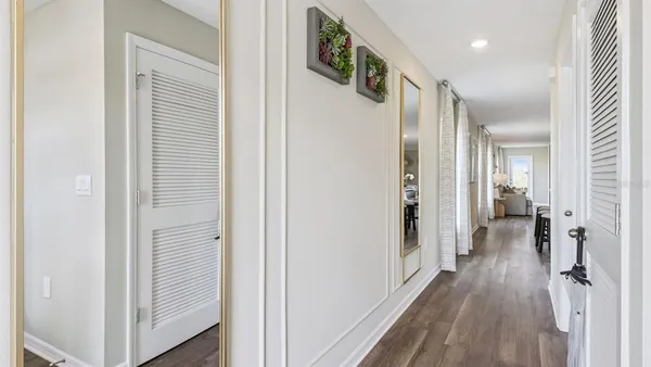 a view of a hallway with wooden floor and staircase