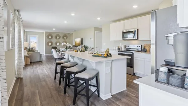 a kitchen with sink refrigerator dining table and chairs