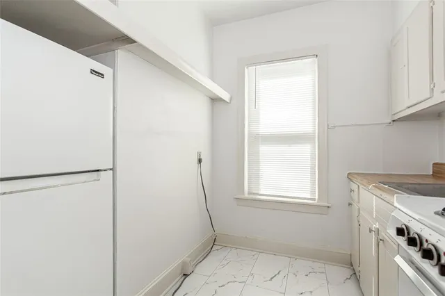 a view of a kitchen with white cabinets washer and dryer
