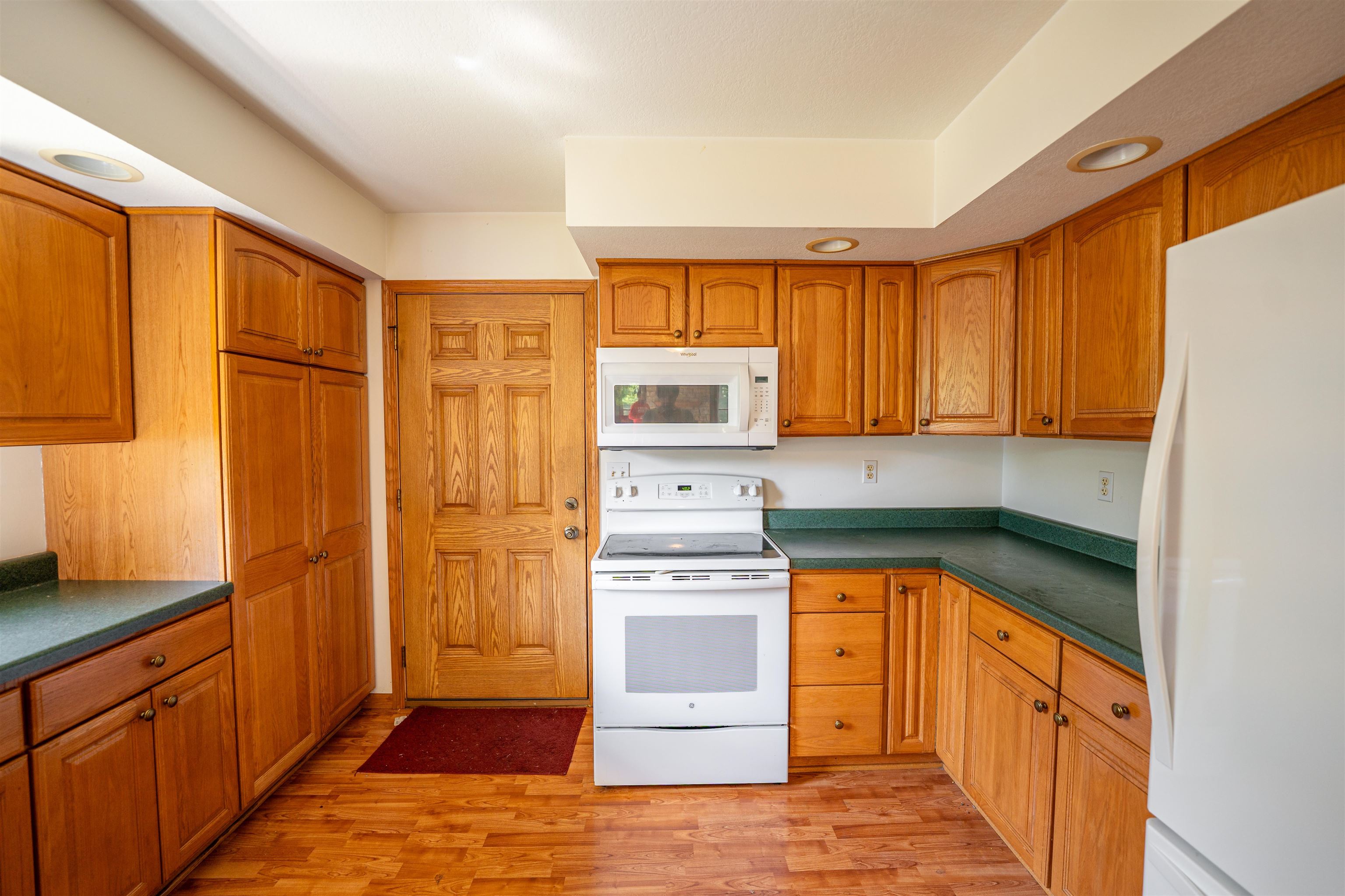 1912 Daysville Road Oregon, IL 61061 - Photo 23 of 74 a kitchen with stainless steel appliances granite countertop a refrigerator a sink dishwasher and wooden cabinets with wooden floor