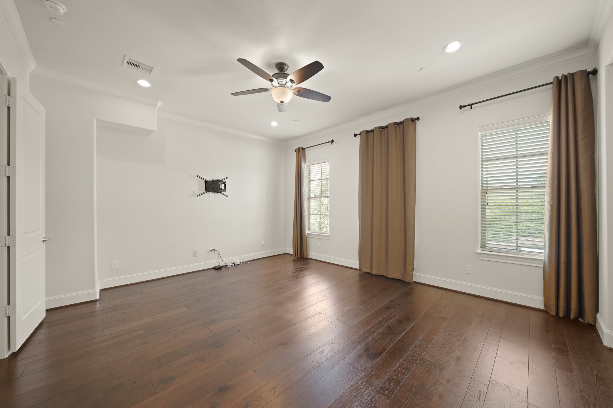 1317 Roy Street Houston, TX 77007 - Photo 19 of 50 The owner’s suite features a ceiling fan with a light fixture, recessed lighting and crown moulding. There’s a wall mount ready for your TV!