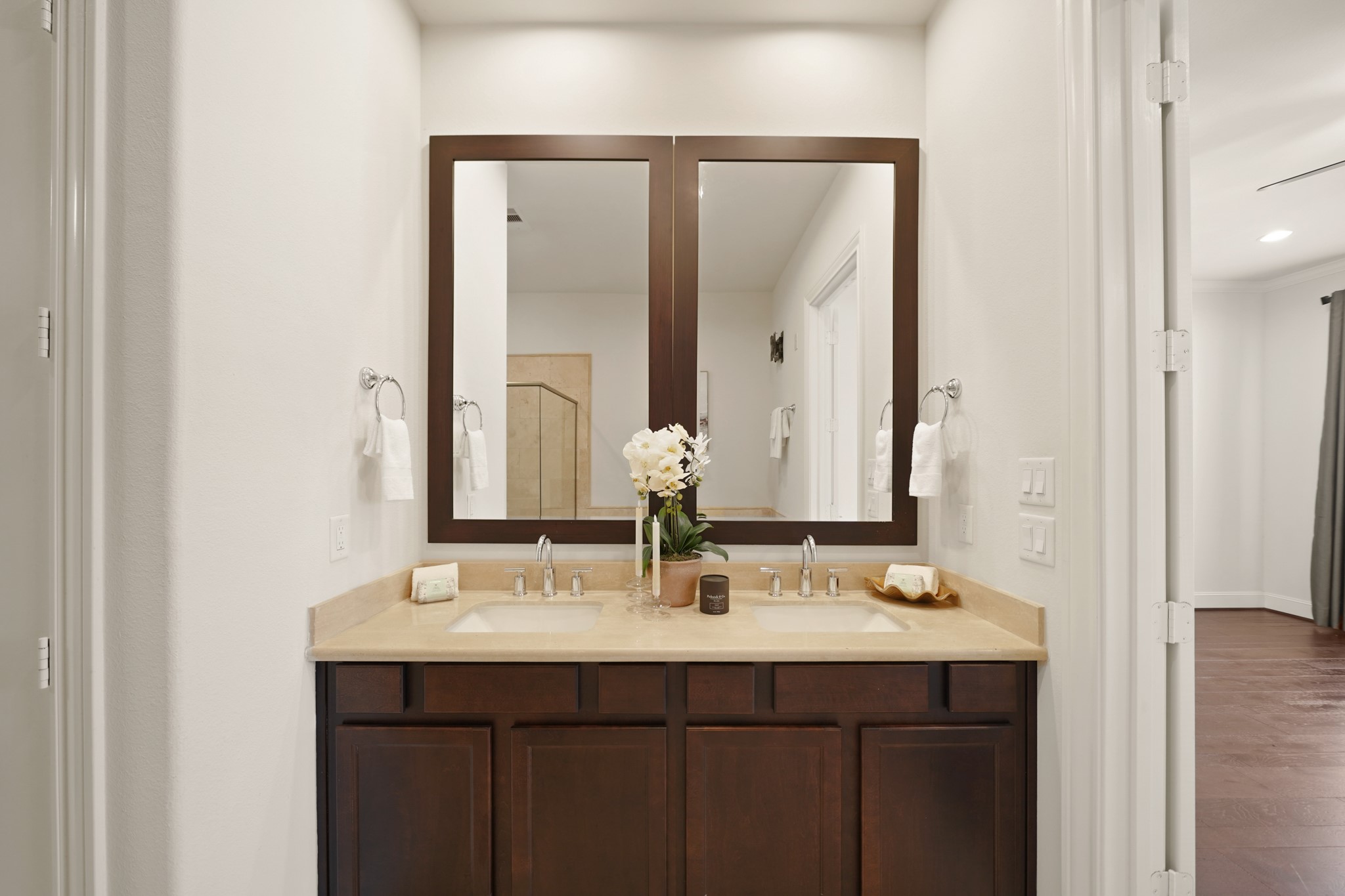 1317 Roy Street Houston, TX 77007 - Photo 23 of 50 Dual sinks with granite counters sit below a framed mirror and chrome plumbing fixtures.