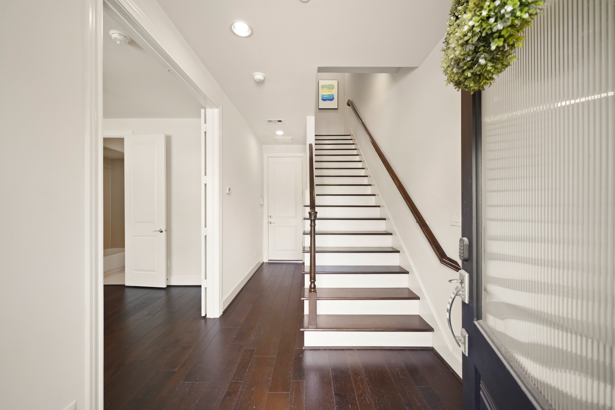 1317 Roy Street Houston, TX 77007 - Photo 3 of 50 Featuring rich hardwood floors, the foyer sets a warm, elegant tone as you enter with recessed lights illuminating the hall to the first-floor bedroom and the garage. Wood treads on the staircase add a polished finish as you ascend to the second floor living area. For the HVAC system, each floor is zoned with its own
thermostat.