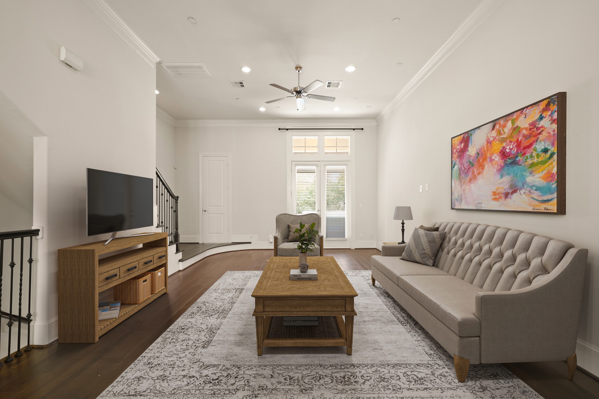 1317 Roy Street Houston, TX 77007 - Photo 6 of 50 Designed to accommodate numerous furniture placement possibilities, the family room features beautiful hardwood floors along with 8-inch baseboards and elegant double crown moulding, adding a touch of sophistication to the space. This room has been virtually staged.