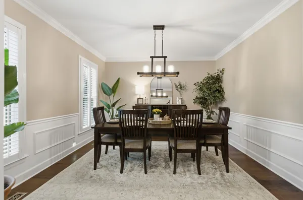 a dining room with furniture a chandelier and wooden floor