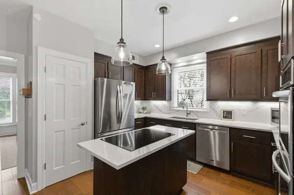 a kitchen that has a sink a window and stainless steel appliances