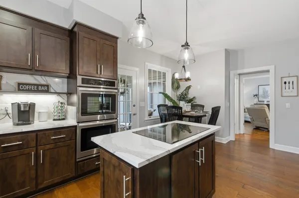 a kitchen with granite countertop a sink and refrigerator