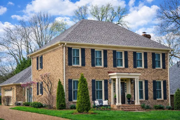 a front view of a house with yard and green space