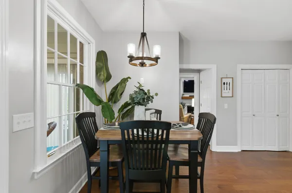 a view of a dining room with furniture a chandelier and wooden floor