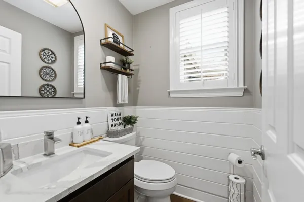 a bathroom with a toilet sink and mirror