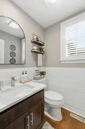a bathroom with a sink a toilet and mirror