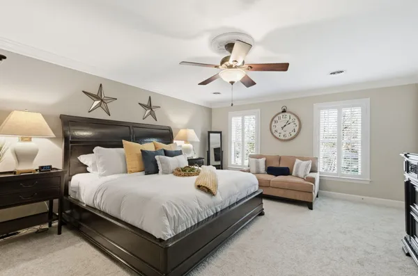 a bedroom with bed and a clock on the dresser