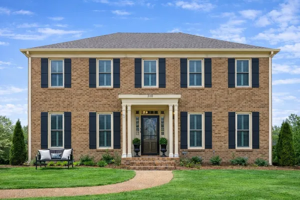 front view of brick house with a yard