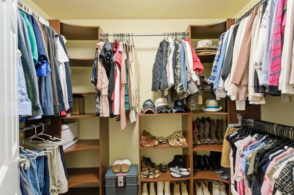 a view of walk in closet with clothes and shoes