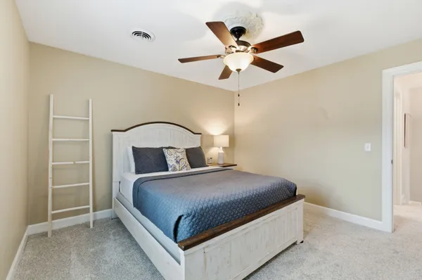 a bedroom with a large bed and a chandelier