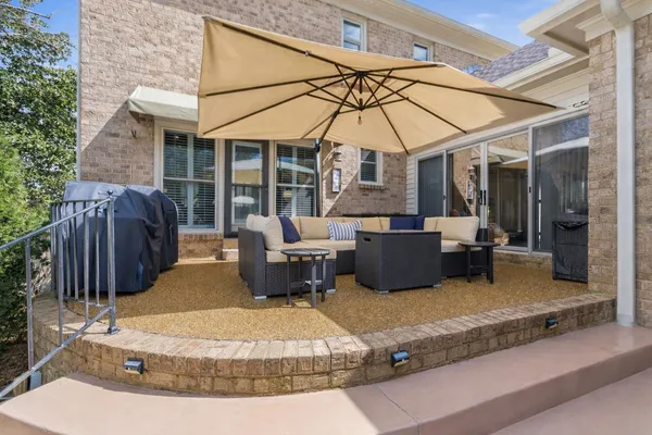 a view of a patio with a table and chairs under an umbrella