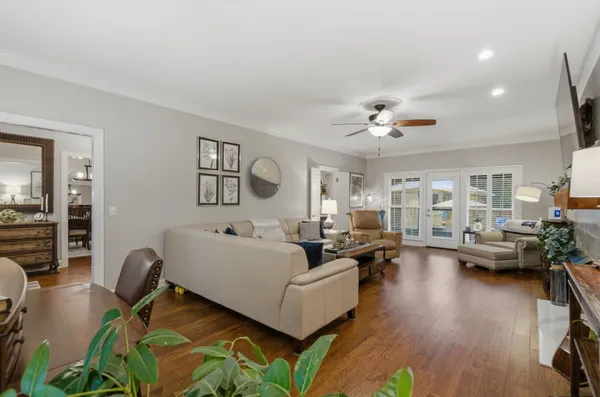 a living room with furniture kitchen view and a wooden floor