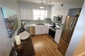 a kitchen with a sink appliances cabinets and a window