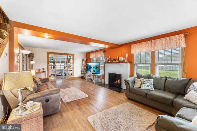 a living room with fireplace furniture and a large window