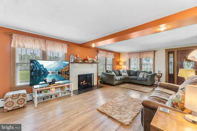 a living room with furniture fireplace and a large window