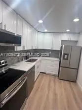 a kitchen with stainless steel appliances granite countertop a sink and a stove
