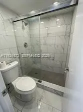 a bathroom with a toilet and a shower