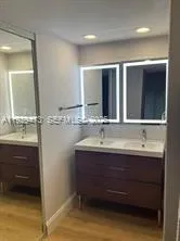 a bathroom with a double vanity sink and a mirror