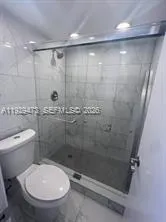 a bathroom with a toilet and a shower