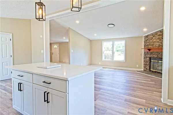 a kitchen with cabinets wooden floor and a window