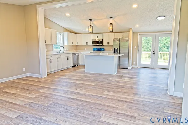 a large kitchen with kitchen island a sink a stove and a refrigerator